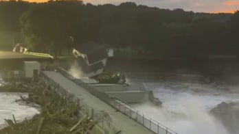 House falls into raging river after dam partially fails