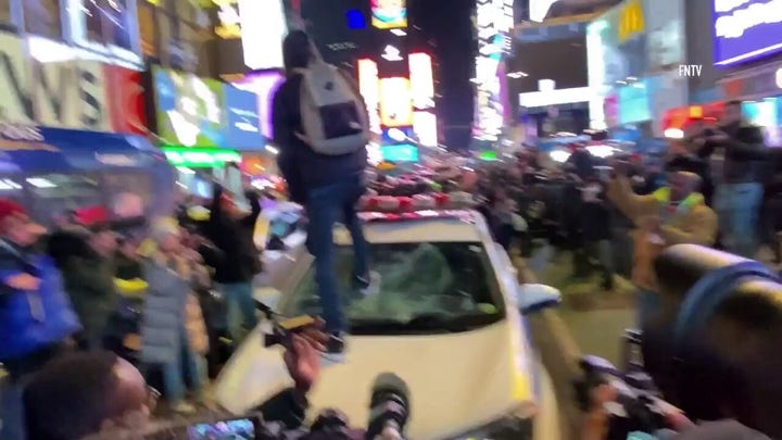 NYC protester is seen getting on police cruiser and smashing window in