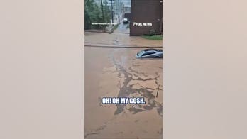 POWERFUL flash flood carries sedan down road
