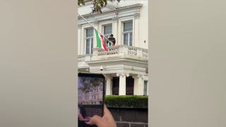 Protester at Iran's embassy in London installs pre-revolution flag after tearing down Islamic regime's symbol