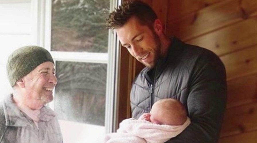 Grandfather walks four miles to see his newborn granddaughter through glass door
