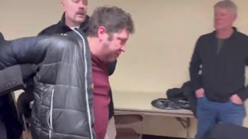 Man escorted out of press conference after appearing to use spray