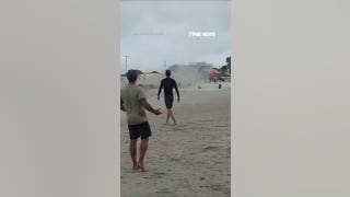 Waterspout turned TORNADO sends beachgoers running for cover
