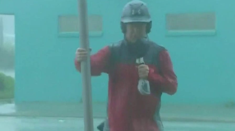 Reporters stand in powerful storms