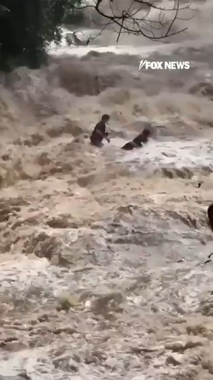 WATCH: Tourists CLING to each other as flood sweeps them away