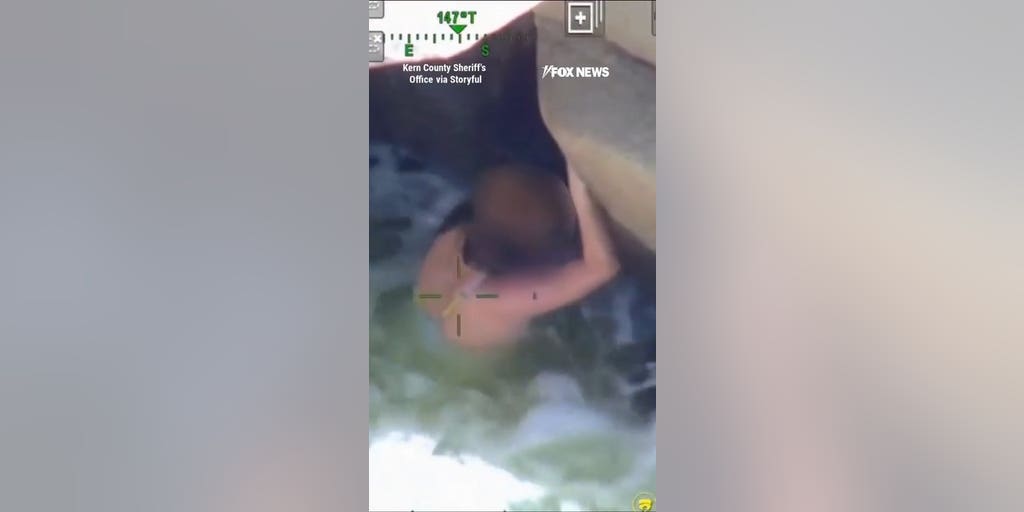 Woman swept away by river found dangling over cliff