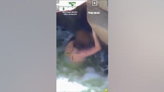 Woman swept away by river found dangling over cliff