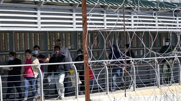 Officials remove migrants under the Del Rio bridge