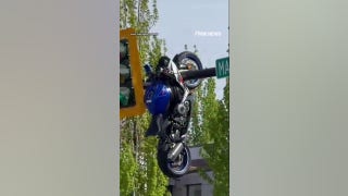 Motorcycle seen HANGING from traffic light after violent crash