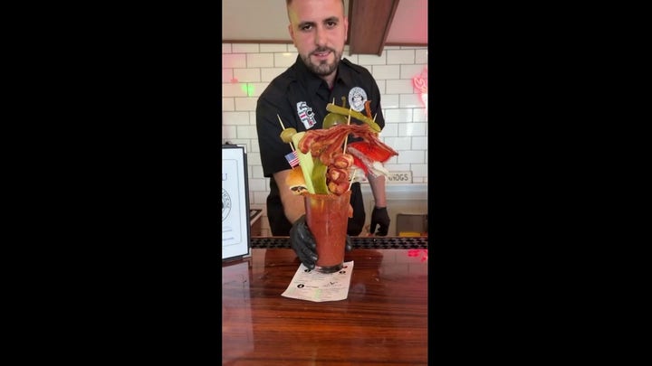 Customers stunned by towering cocktail garnished with lobster claw and shrimp
