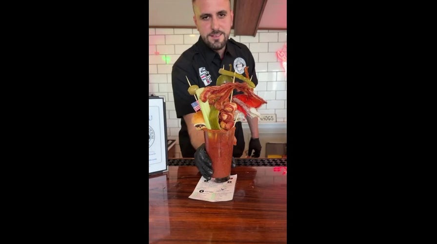 Customers stunned by towering cocktail garnished with lobster claw and shrimp