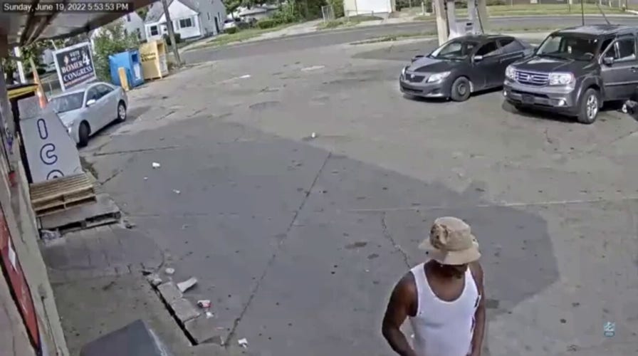디트로이트 주유소 비디오는 무장한 용의자가 아기를 어깨에 안고 있는 남성에게 총을 겨누는 모습을 보여줍니다.