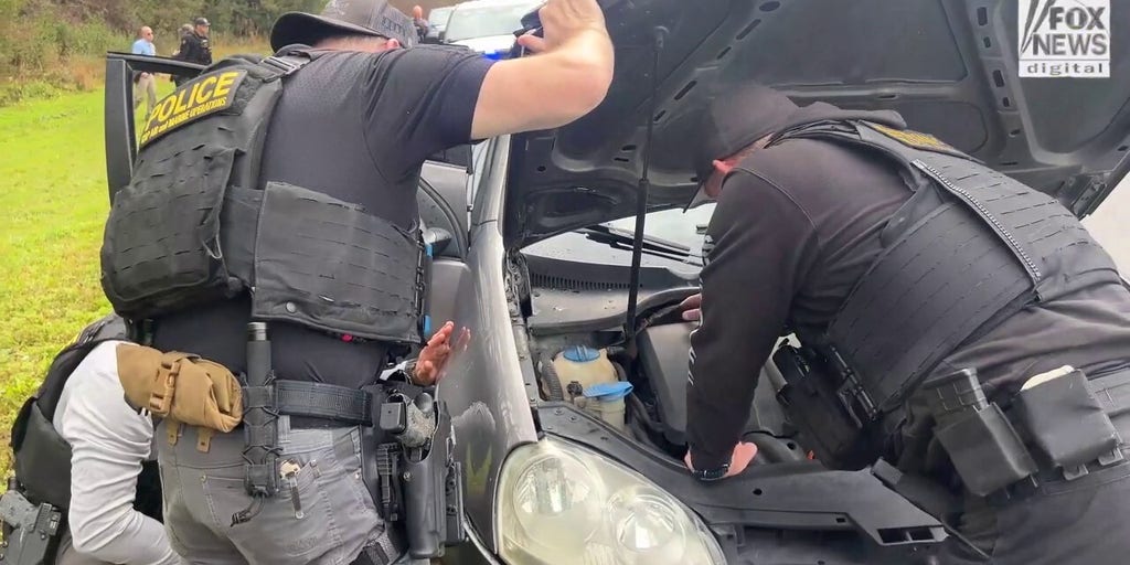 Law enforcement officers search suspects' vehicle for illicit drugs