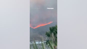Flames race across California hillside as Santa Ana winds arrive 