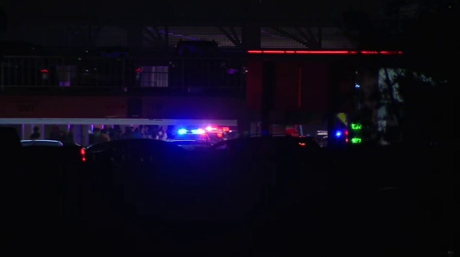 Police escort shoppers retired  of California promenade  aft  Black Friday shooting