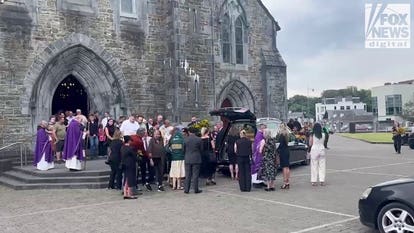 Mourners gather around murdered American mother Jamey Carney's hearse outside Killarney cathedral