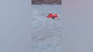 Firefighters crawl across thin ice to rescue dog trapped in frozen pond