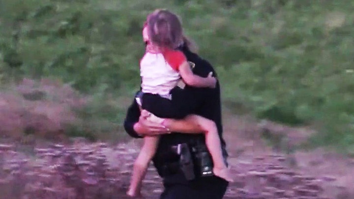 Police officer hailed a hero after scaling down cliff to save twin girls