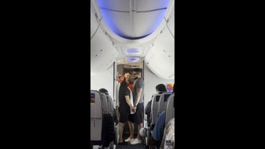 Bride walks down airplane aisle in toilet paper veil during surprise sky-high wedding