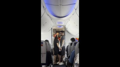 Bride walks down airplane aisle in toilet paper veil during surprise sky-high wedding