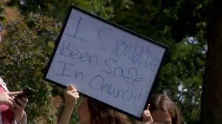 Pride flag protesters stand across from Vance as VP visits church shooting memorial
