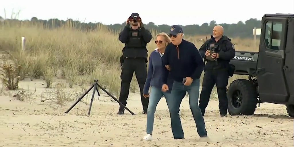 President Biden appears to struggle while walking on beach with first lady