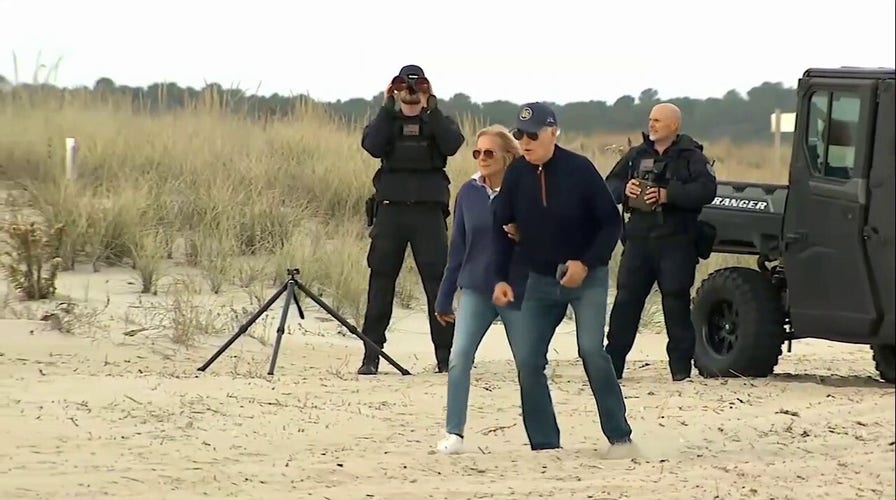 President Biden seems to struggle while walking on beach