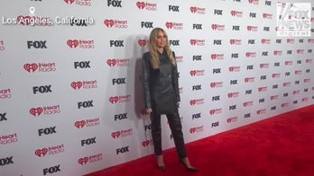 Miley Cyrus poses for photos on the red carpet at the iHeartRadio Music Awards