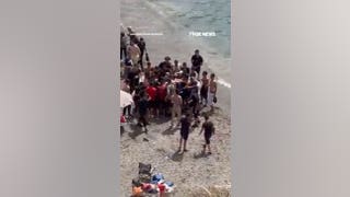 Beachgoers abandon shore as migrant boat arrives on Spanish coast