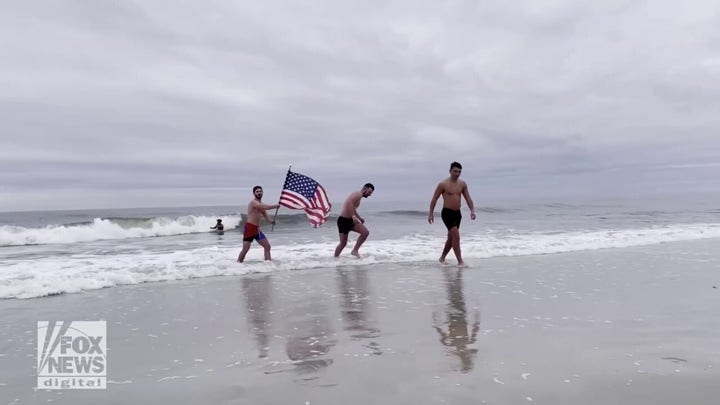 Polar plungers wave an American flag after a weekly dip in the Atlantic Ocean, above.