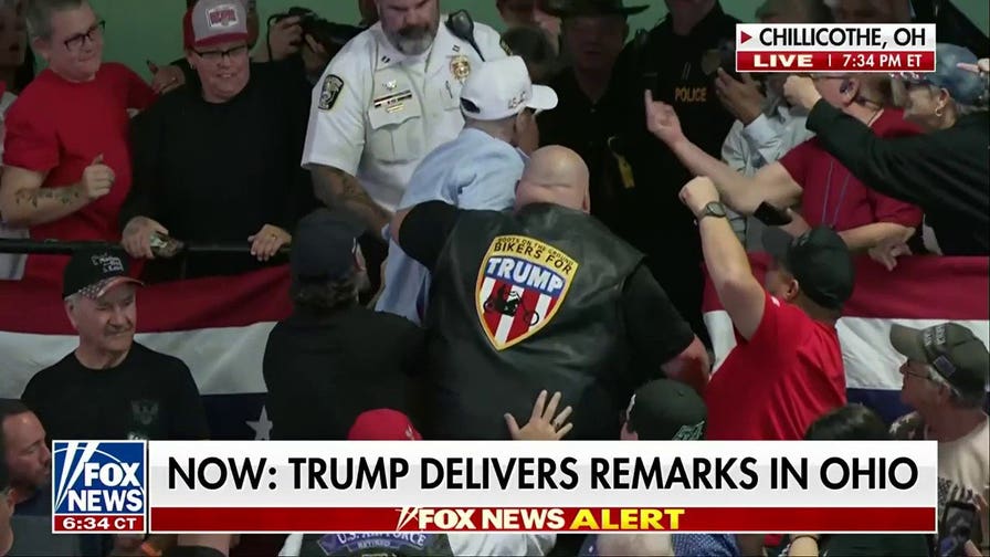 Bikers for Trump member escorts protester out of Trump rally as audience erupts in ‘U-S-A’ chant