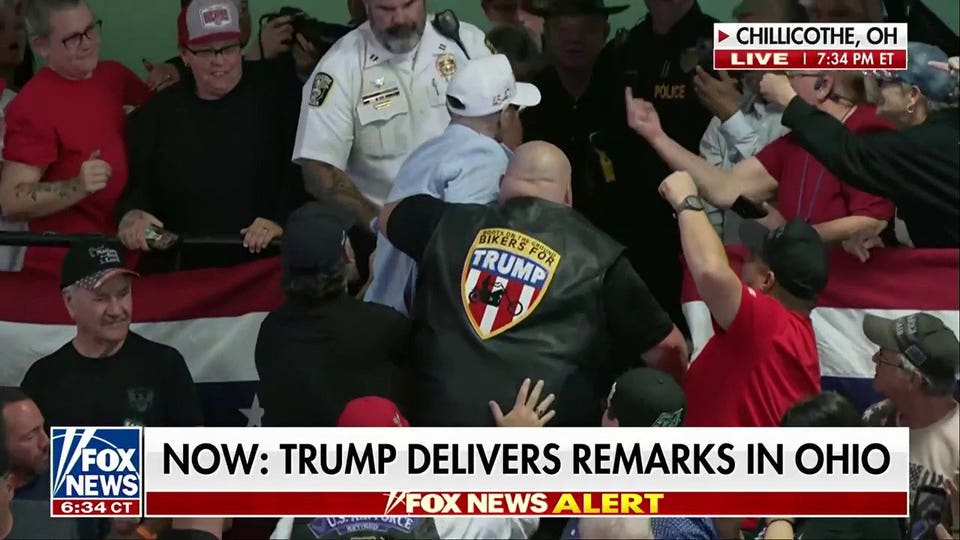 Bikers for Trump member escorts protester out of Trump rally as audience erupts in ‘U-S-A’ chant