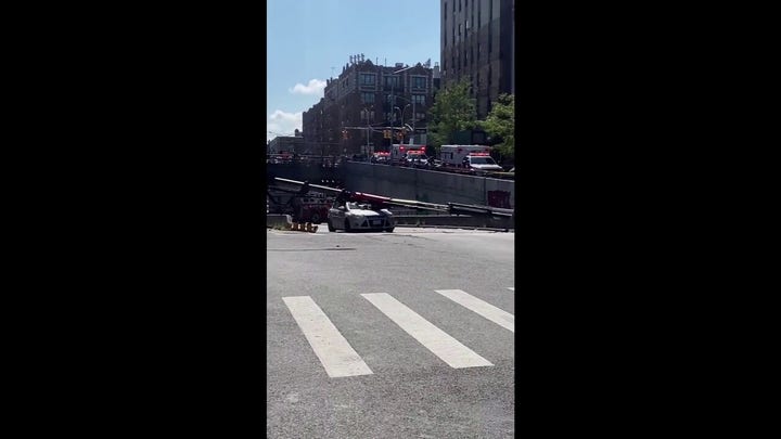 New York City boom crane collapses onto roadway, crushing a car 