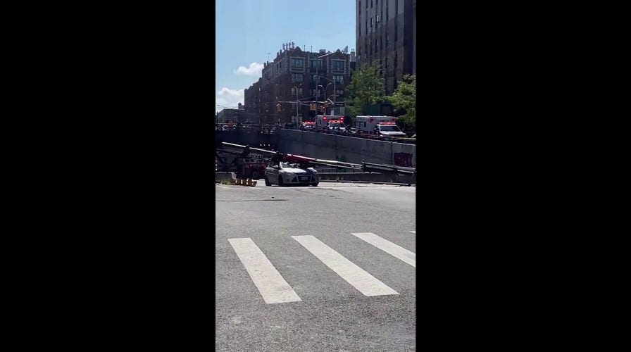 New York City boom crane collapses onto roadway, crushing a car 