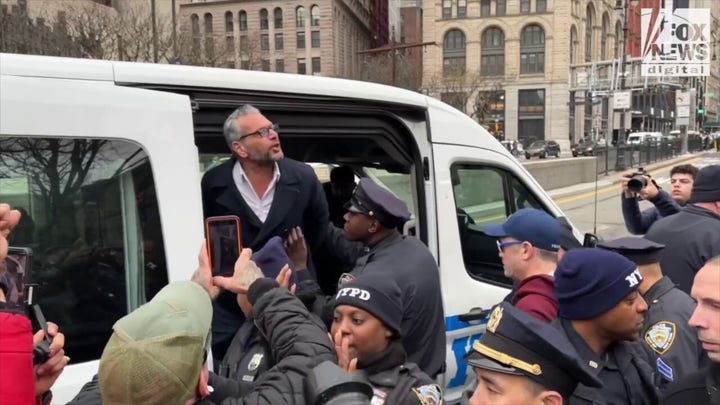 Scott LoBaido is arrested after throwing pizza over the gates of New York City Hall
