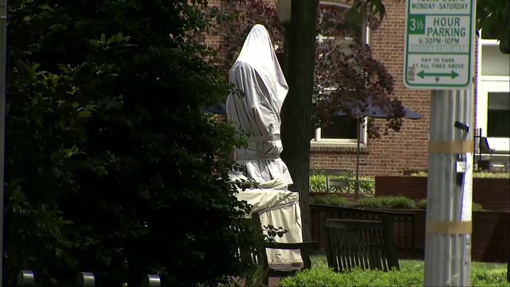 George Washington statue covered after police clear encampment at namesake university