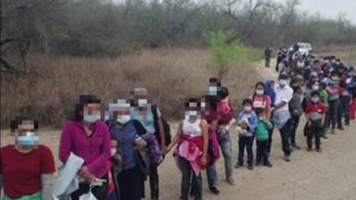 Federal agents apprehending large groups of migrants crossing the US-Mexico border