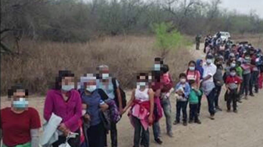 Federal agents apprehending large groups of migrants crossing the US-Mexico border
