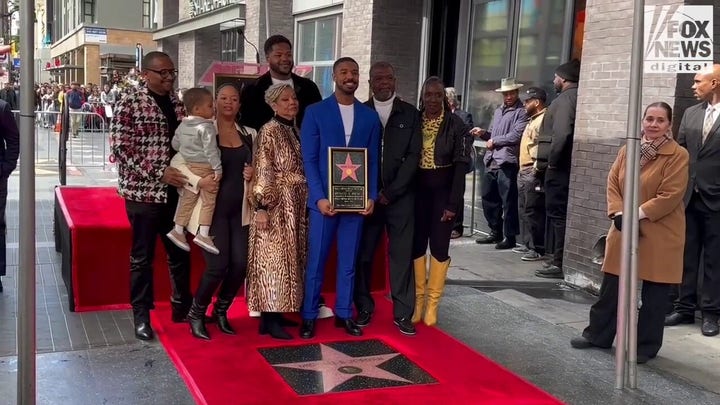 Michael B. Jordan poses in front of his star on the Hollywood Walk of Fame with his family