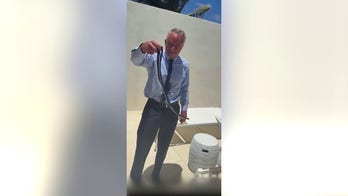 Robert F. Kennedy Jr. grabs two snakes on Dr. Mehmet Oz's patio