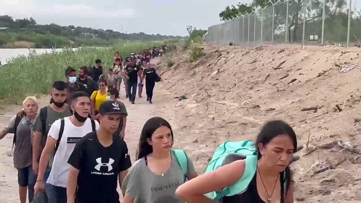 Fox News footage shows a large group of migrants walking across the US-Mexico border