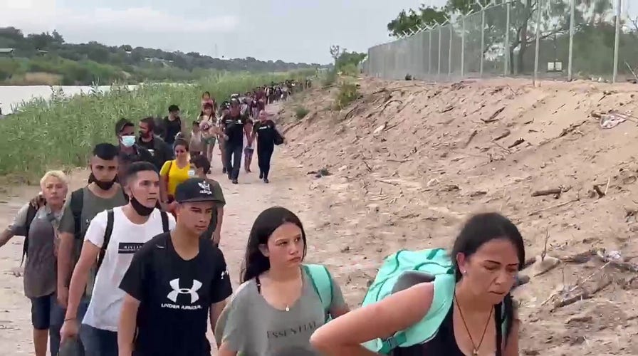 Fox News footage shows a large group of migrants walking across the US-Mexico border