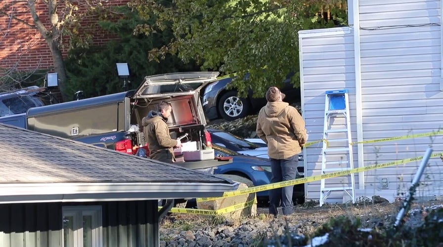 Investigators seen gathering evidence outside home where four students were killed