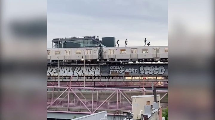 NYC subway surfers seen atop train crossing bridge 