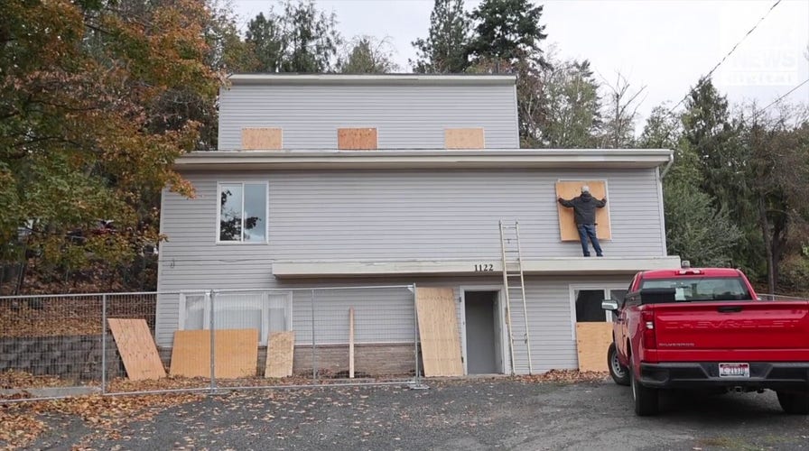 Investigators replace the plywood over the doors and windows to the home where four University of Idaho students were stabbed to death last year 