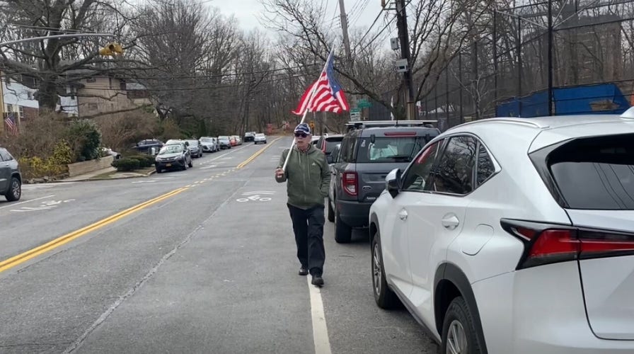 '14,000 Russian soldiers dead,' yells the protester with an American flag at the Russians