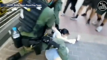 Police in Hong Kong tackle young girl to ground