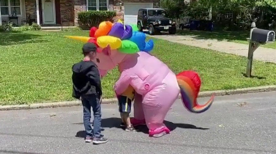 Grandmother wears pink unicorn costume to safely hug her grandchildren