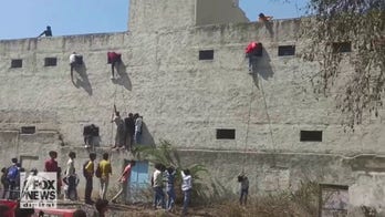 Students caught on video grabbing 'cheat sheets' from people who climbed school wall