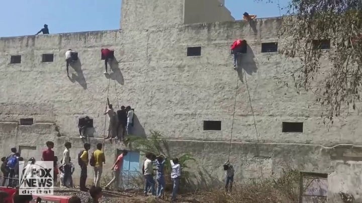 Students caught on video grabbing 'cheat sheets' from people who climbed school wall